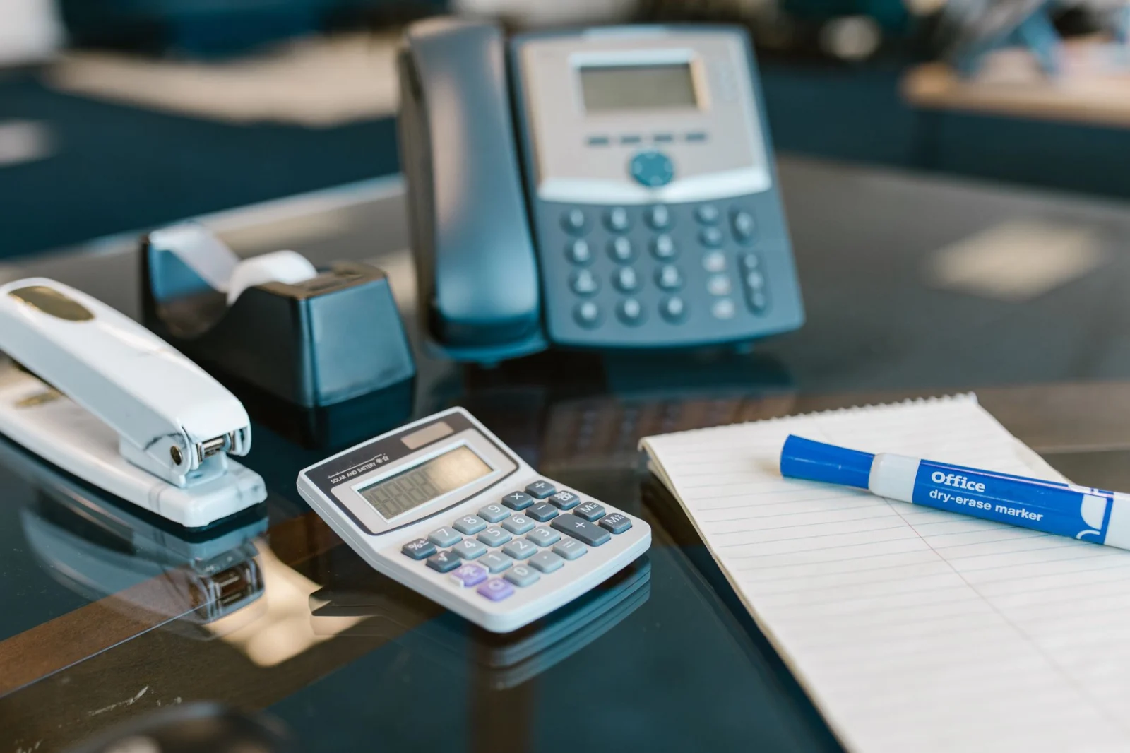 Ofis masasında telefon, hesap makinesi ve not kâğıtları